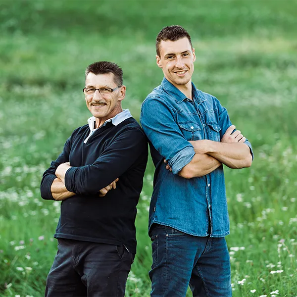 Walter und Patrick Engler stehen mit verschränkten Armen auf Wiese.